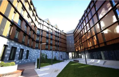 a large building with a courtyard in front of it at Woodside Apartman Kopaonik 315 in Kopaonik