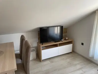 a living room with a flat screen tv on a stand at Vuk apartment - Milmari Resort & Spa in Kopaonik