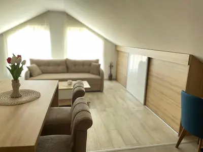 a living room with a table and a couch at Vuk apartment - Milmari Resort & Spa in Kopaonik