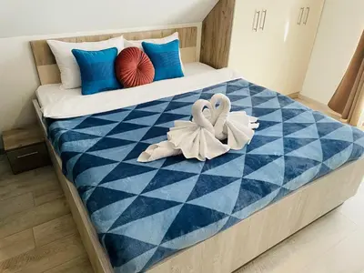 a bed with two white towels on top of it at Vuk apartment - Milmari Resort & Spa in Kopaonik