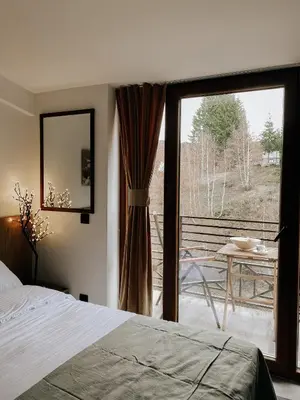 a bedroom with a bed and a sliding glass door at Zlatokosina zona Kopaonik Milmari NLux in Kopaonik