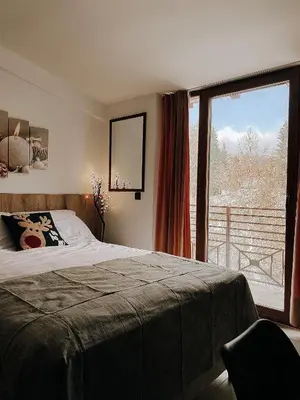 a bedroom with a bed and a large window at Zlatokosina zona Kopaonik Milmari NLux in Kopaonik