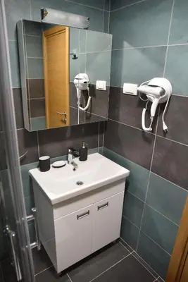 a bathroom with a white sink and a mirror at Apartman LUCIJA 9D57 Kraljevi Cardaci in Kopaonik