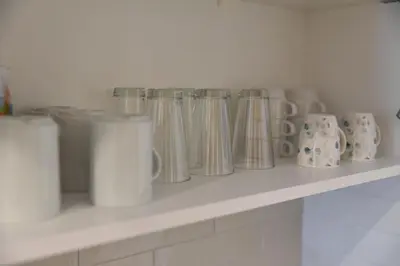 a shelf with a bunch of cups and vases at Apartman LUCIJA 9D57 Kraljevi Cardaci in Kopaonik