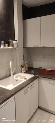 a kitchen with white cabinets and a white sink at VIN Studio in Kruševac