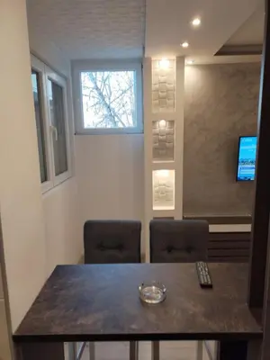 a room with a table and two chairs and a television at VIN Studio in Kruševac