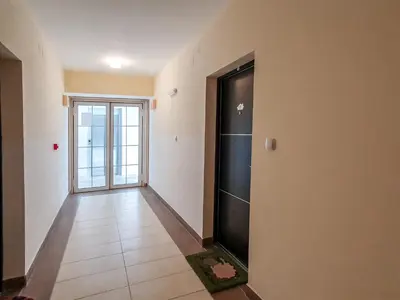 a hallway with a black door and a tile floor at Apartman Cvejic - Suncani apartmani in Brzeće