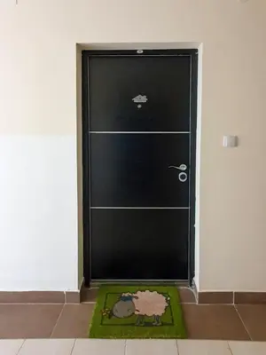 a black door with a mat in front of it at Apartman Cvejic - Suncani apartmani in Brzeće