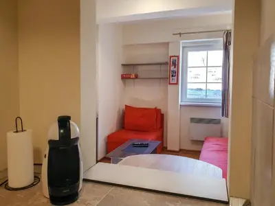 a room with a bed and a chair and a window at Apartman Cvejic - Suncani apartmani in Brzeće