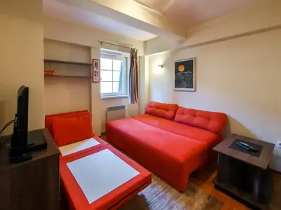 a living room with a red couch and a tv at Apartman Cvejic - Suncani apartmani in Brzeće