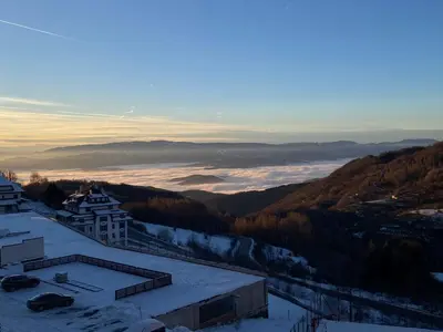 a view of a snow covered mountain with a city at Apartmani Srna Milmari in Kopaonik