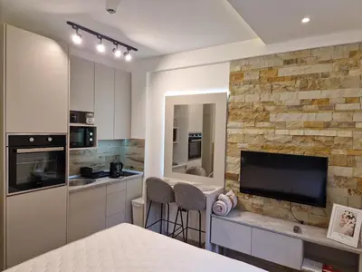 a room with a bed and a tv and a kitchen at Apartmani Srna Milmari in Kopaonik