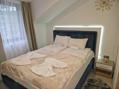 a bedroom with a bed with towels on it at Apartmani Srna Milmari in Kopaonik