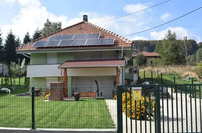 a house with solar panels on the roof at Apartmani Gočki San in Biserske Kuće