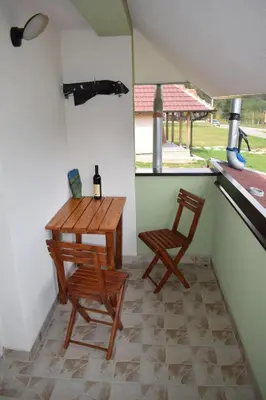 a table and two chairs in a room at Apartmani Gočki San in Biserske Kuće