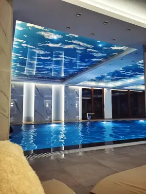 a large swimming pool with a ceiling filled with blue water at FIONA Kopaonik in Kopaonik