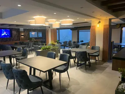 a restaurant with tables and chairs and windows at FIONA Kopaonik in Kopaonik