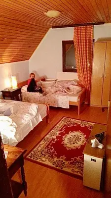 a woman sitting on a bed in a bedroom at Petra in Kopaonik