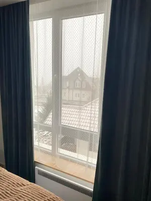 a bedroom window with a view of a house at Jankov konak in Kopaonik