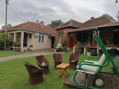 a yard with chairs and a swing and a house at Markov konak in Babušnica