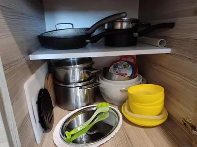 a kitchen shelf with pots and pans and utensils at Apartman Tiva - Milmari Resort-garažno mesto-GRATIS in Kopaonik