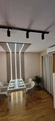 a living room with a white table and chairs at Apartman La Campanella 1 in Vrnjačka Banja