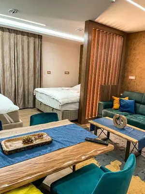 a room with two beds and a table and chairs at Diamond Kopaonik Centar in Kopaonik