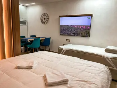 a room with two beds and a tv on the wall at Diamond Kopaonik Centar in Kopaonik