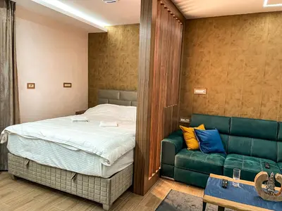 a bedroom with a bed and a couch at Diamond Kopaonik Centar in Kopaonik