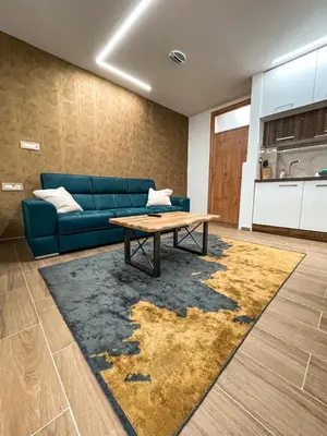 a living room with a blue couch and a table at Diamond Kopaonik Centar in Kopaonik
