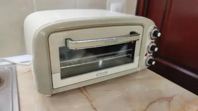 a toaster oven sitting on a kitchen floor at Apartman Vivaldi - CENTAR in Vrnjačka Banja