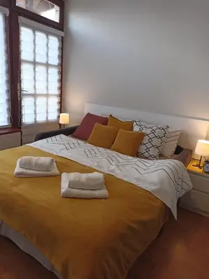 a bedroom with a large bed with two towels on it at MonteCasa in Vrnjačka Banja