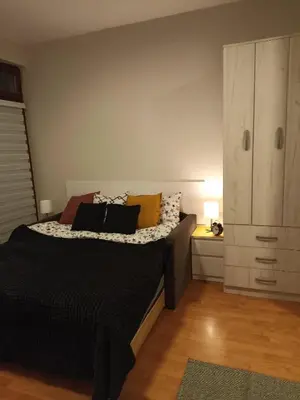a bedroom with a bed with pillows and a cabinet at MonteCasa in Vrnjačka Banja