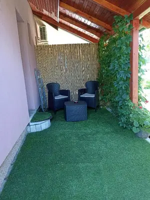 a patio with green grass and chairs under a pergola at MonteCasa in Vrnjačka Banja