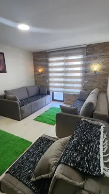 a living room with couches and a green rug at Kopaonik in Kopaonik