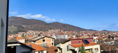 a city with houses and mountains in the background at Marinkovic stan na dan in Vranje