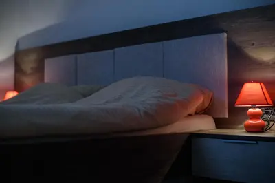 a bed with a headboard and a lamp on a table at Apartman Leki in Kopaonik