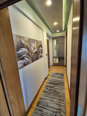 a hallway with a painting of flowers on the wall at Promenada Grujić in Vrnjačka Banja