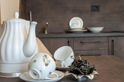 a table with a vase and plates on it at Promenada Grujić in Vrnjačka Banja