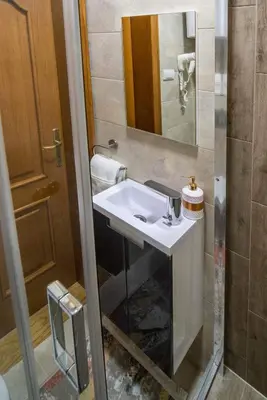 a bathroom with a white sink and a mirror at Promenada Grujić in Vrnjačka Banja
