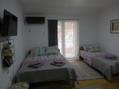 two beds in a room with a window at Studio Centar Park in Soko Banja