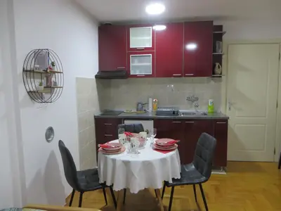 a kitchen with a table with a white table cloth at Studio Centar Park in Soko Banja