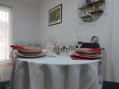 a table with plates and wine glasses on it at Studio Centar Park in Soko Banja