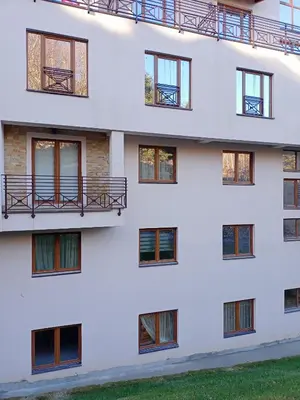 a white building with windows and a balcony at Milmari N Lux 52 in Kopaonik
