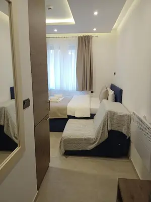 a small bedroom with two beds and a window at Milmari N Lux 52 in Kopaonik