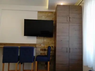 a room with three chairs and a television on a wall at Milmari N Lux 52 in Kopaonik