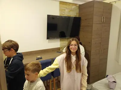 a girl and two boys standing in a room at Milmari N Lux 52 in Kopaonik