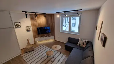 a living room with a couch and a tv at Xenia Apartment in Kopaonik
