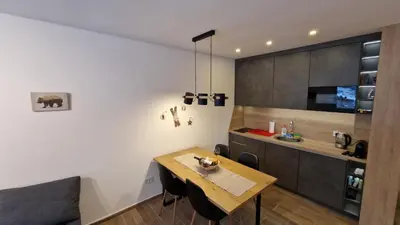a kitchen and dining room with a wooden table at Xenia Apartment in Kopaonik