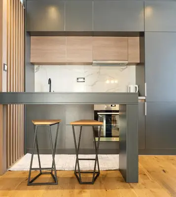 a kitchen with a counter and two stools at Vila Golija in Kopaonik